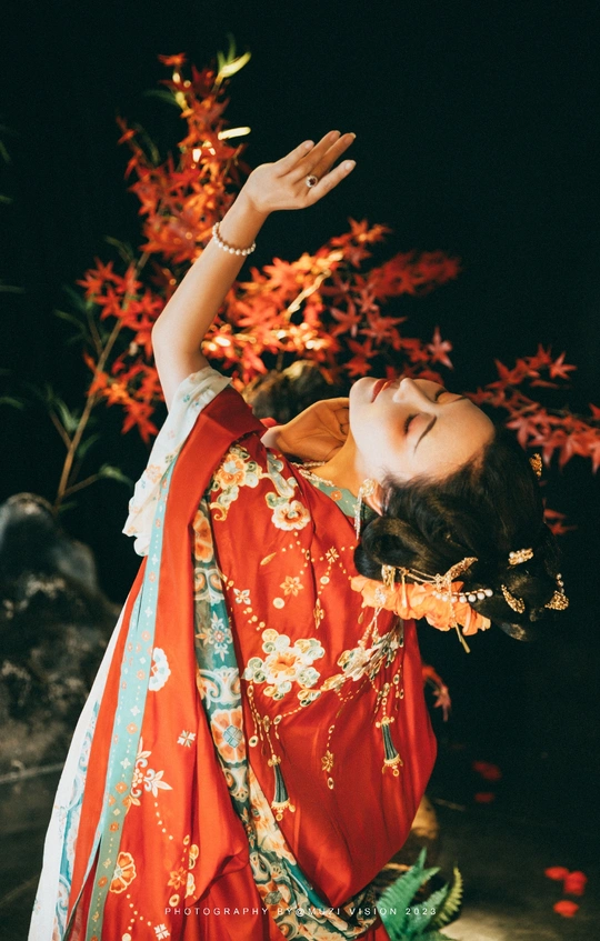 一位穿着红色和服的年轻女子正在跳传统的舞蹈。