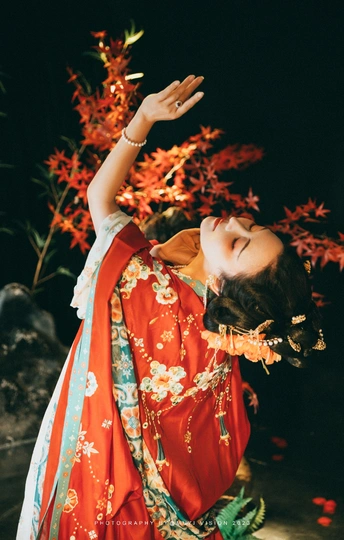 一位穿着红色和服的年轻女子正在跳传统的舞蹈。