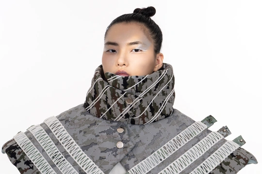 一位女士戴着围巾 举起一张纸靠近她的脸