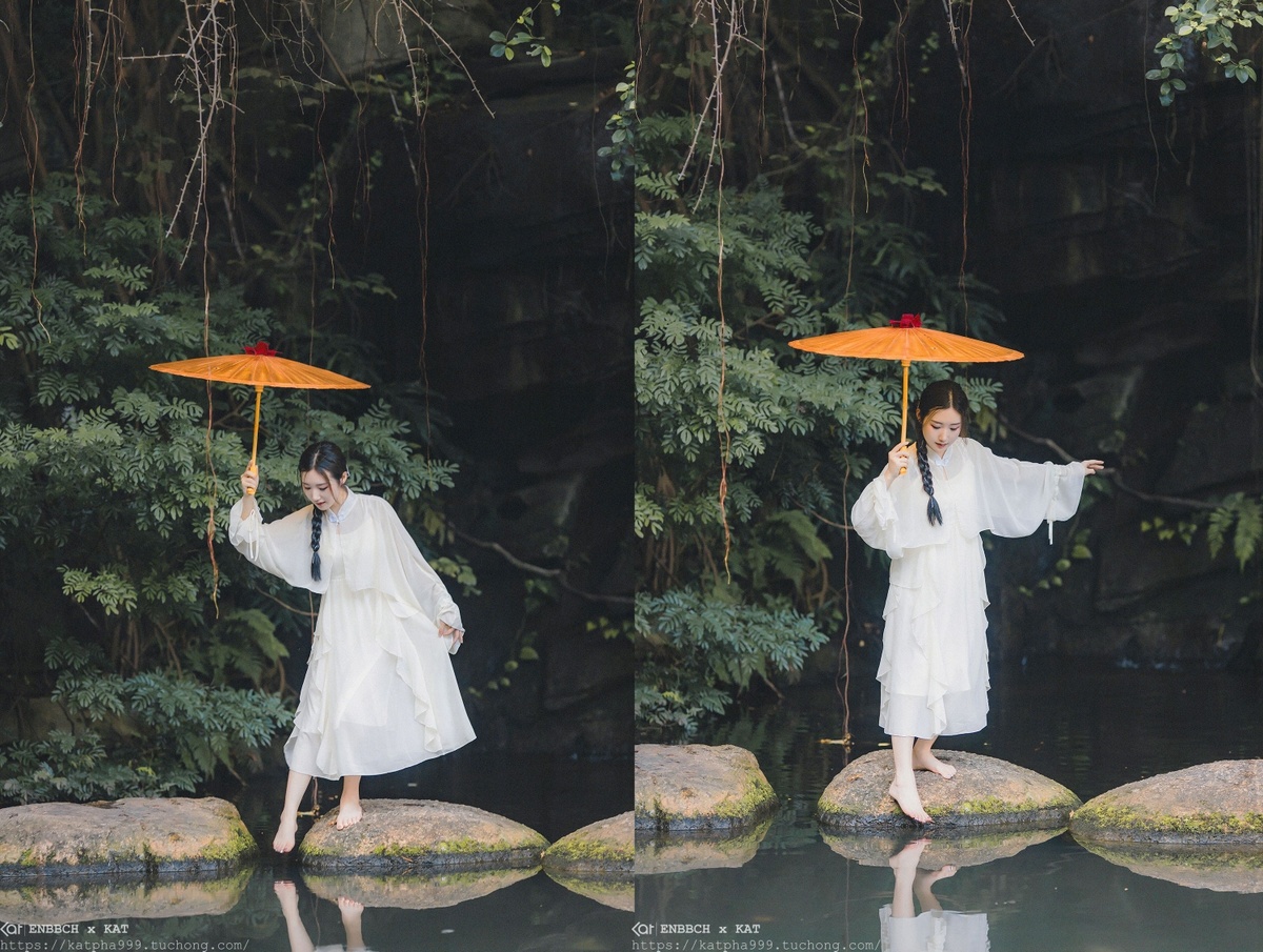 一位穿着白色连衣裙 手持雨伞站在岩石上的女人