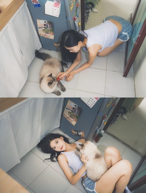 一位年轻女士正在抚摸一只躺在地板上的猫。