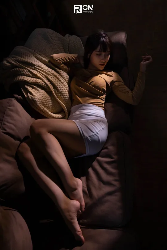 一位年轻女子躺在黑暗的床上沉睡。