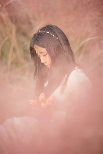 一位年轻女子坐在草地上花丛中的人物肖像