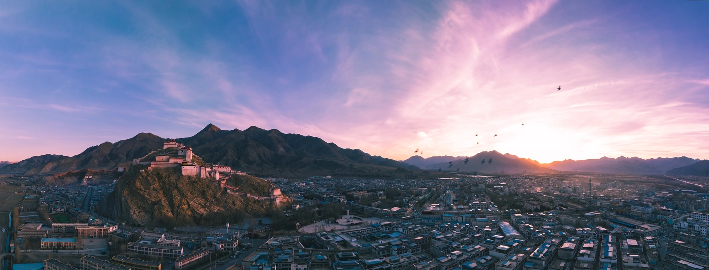 前景有山 背景为落日的一个城市