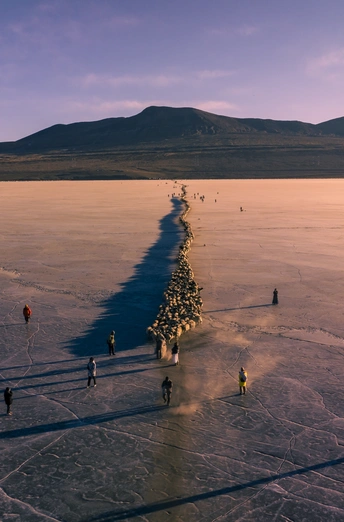 一群人在日落时穿越一个结冰的湖