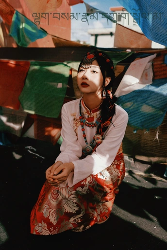 一位穿着传统服装的年轻女子坐在人行道上。