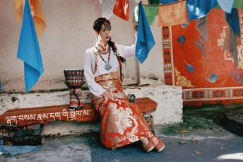 一位穿着传统服装的年轻女子坐在长凳上