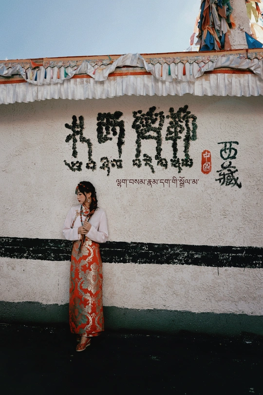 一位站在有亚洲文字的墙前的女性正在打电话