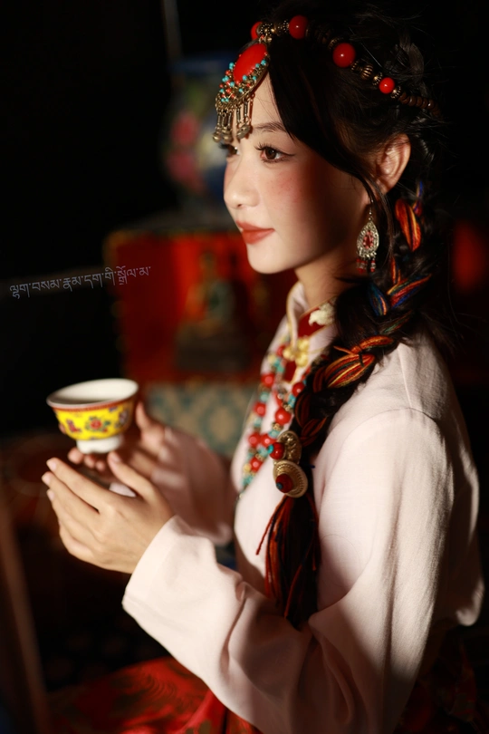 一位穿着美洲原住民服装的年轻女子手持一杯茶或咖啡。