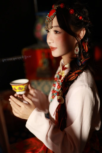 一位穿着美洲原住民服装的年轻女子手持一杯茶或咖啡。