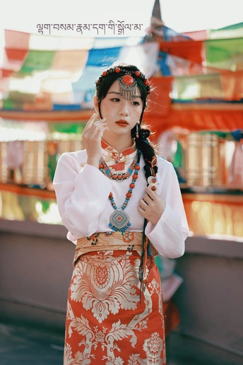 一位穿着传统服装的年轻女子在雨伞下摆姿势