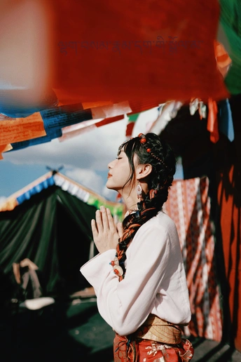 一位穿着传统服装的年轻女子在节日下站在一把伞下