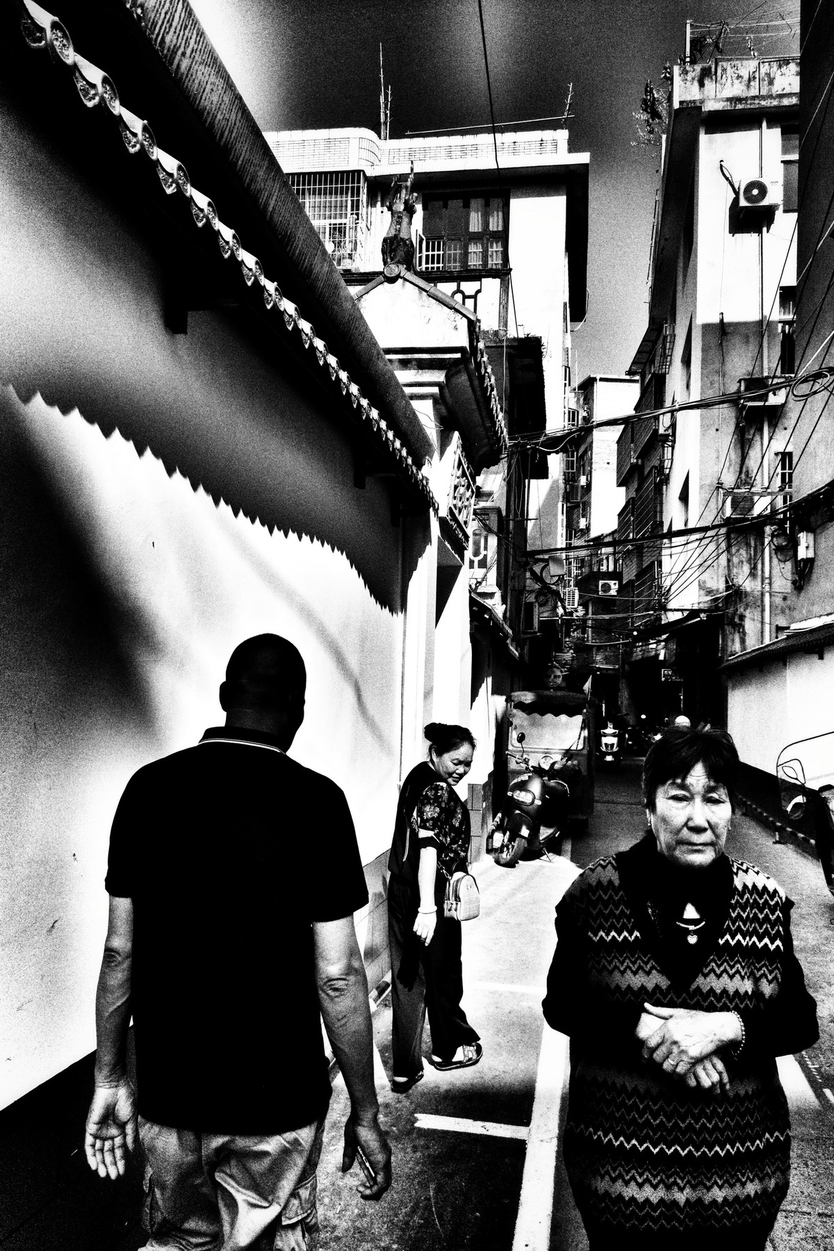 一条狭窄的街道上行走的人们黑白照片