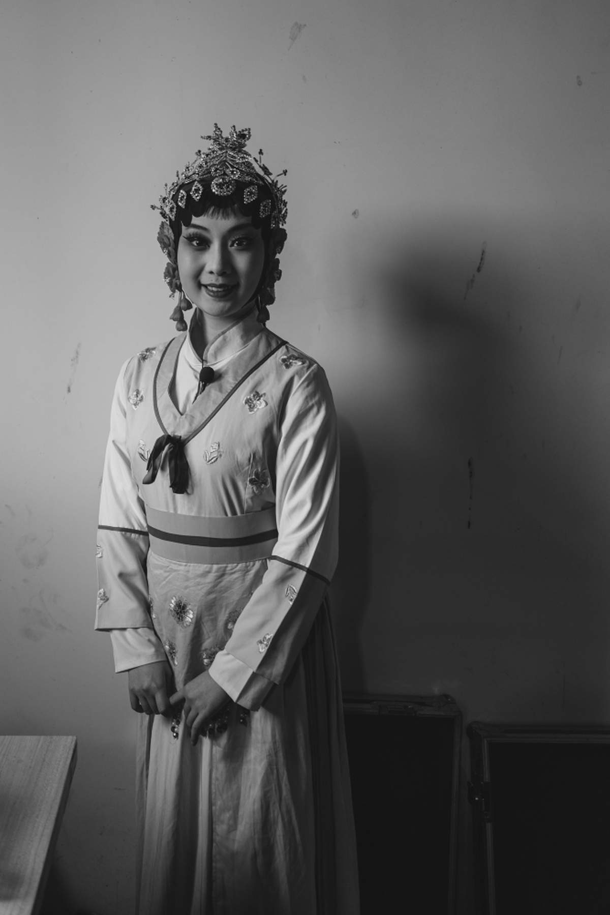 一张黑白照片 一位年轻女子身着花 costume 装 在房间中摆姿势