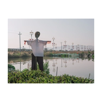 一个人站在湖或河的前面 伸开双臂。