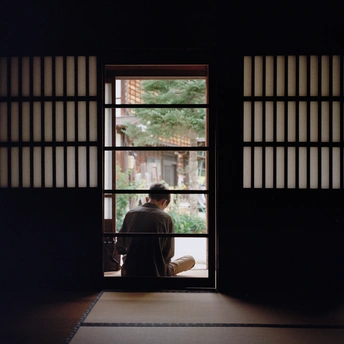 一个人坐在房间里 透过打开的窗户向外看