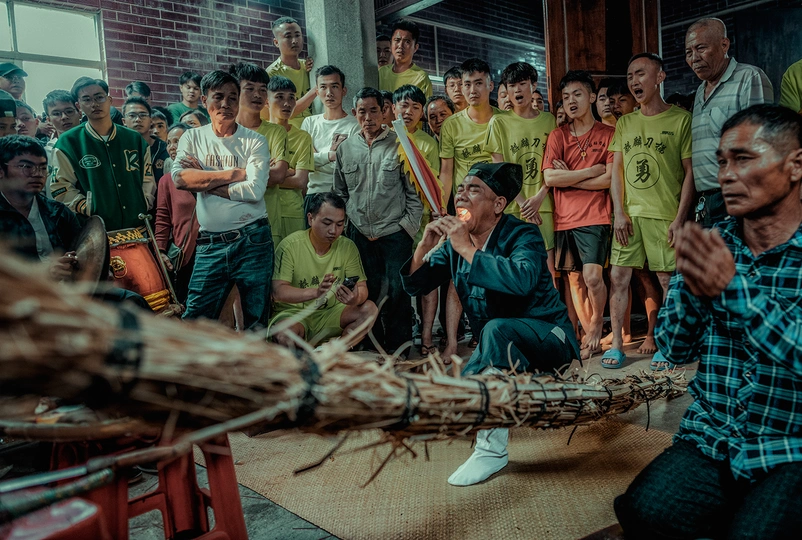 人群在观看一个拿着棍子的男人