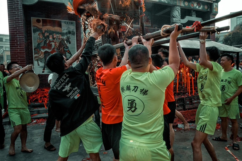 一个穿绿色衬衫的男子举着火炬 带领一群人穿过节日。