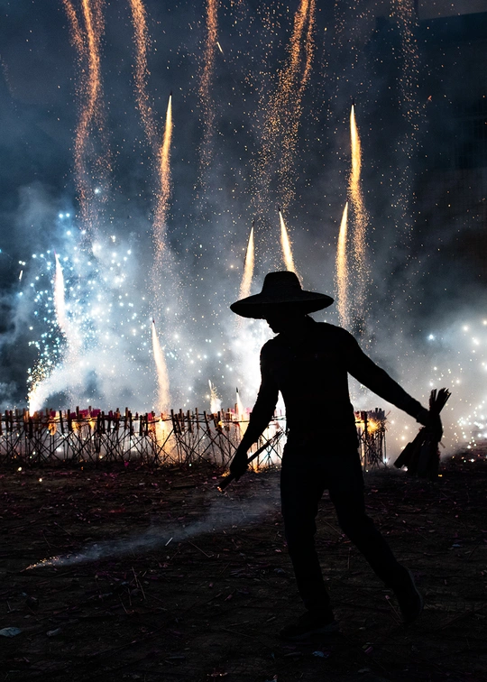 一个戴帽子的人在天空观看烟花