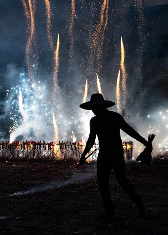 一个戴帽子的人在天空观看烟花