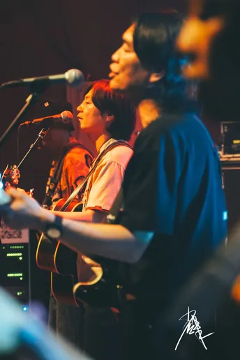 图片可能包含人、舞台上、演奏乐器、夜晚和室内。