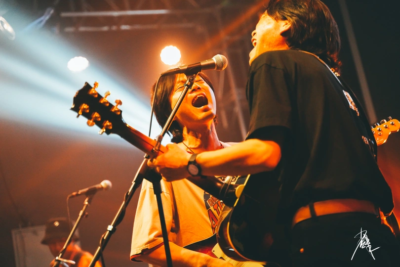 一个人在舞台上弹吉他 一个音乐艺术家对着麦克风唱歌