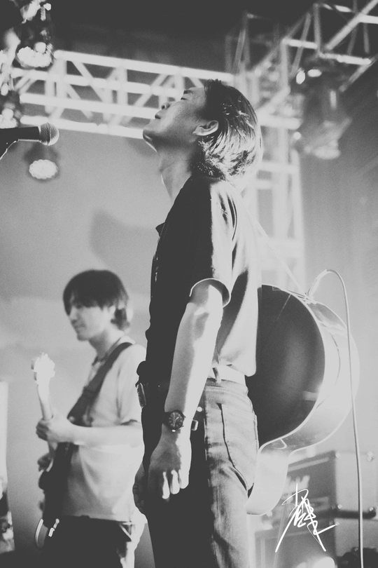 一张黑白照片 一个男子在音乐会舞台上演奏乐器