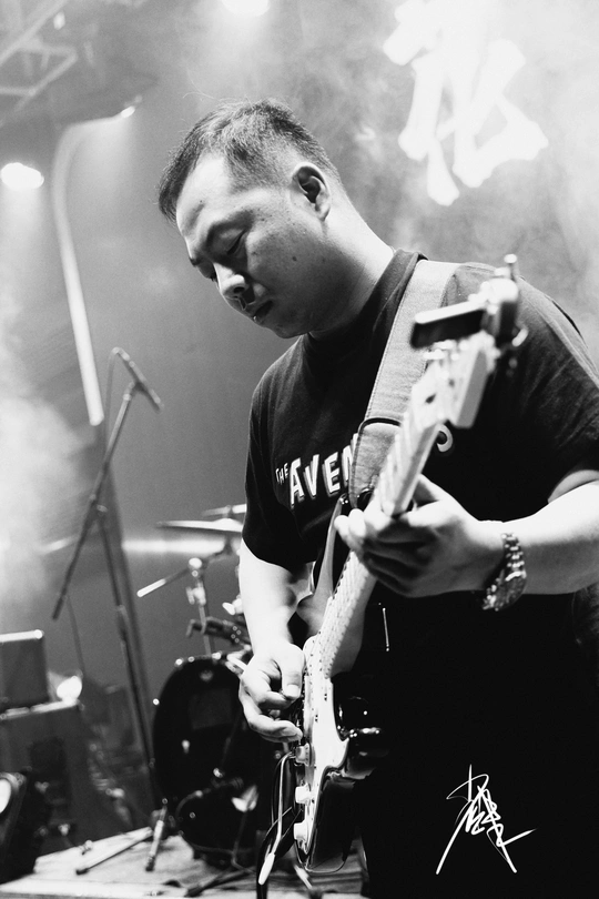 一张黑白照片 一个男子在音乐会舞台上演奏乐器