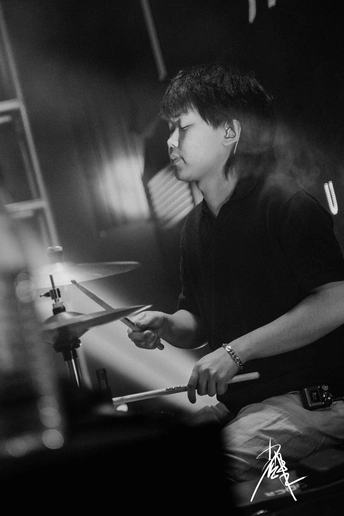 一个黑白图像 展示一个男子在夜晚舞台上演奏乐器。