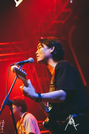 图片可能包含一个人在舞台上弹奏乐器 夜晚 音乐会和麦克风。