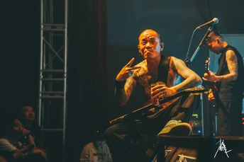 一个人在舞台上为人群演奏音乐会