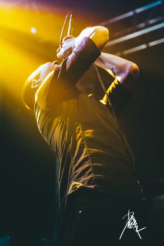 一张男子在音乐会舞台上表演的照片