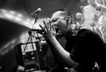 一张黑白图片 展示一个男子在舞台上演奏乐器。