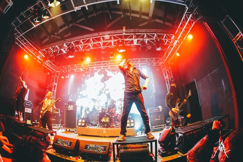 一个人在乐队中在舞台上表演 前面有观众。