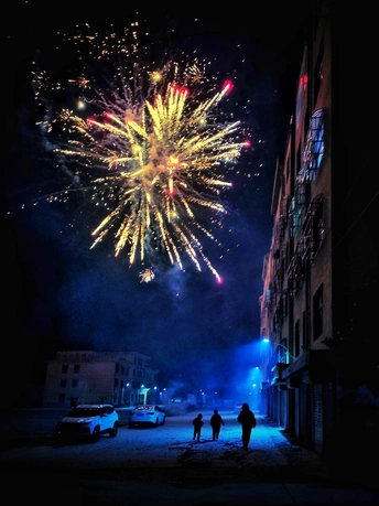 夜晚的城市街道 人们观看烟花照亮天空。