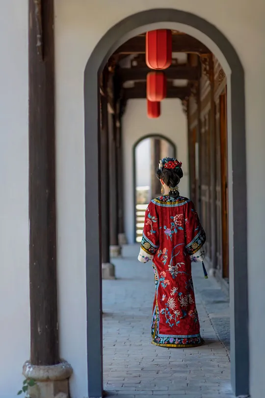 一位穿着红裙子的女人正在走下走廊