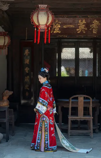 一位穿着和服的女性站在一个有红色雨伞的房间里