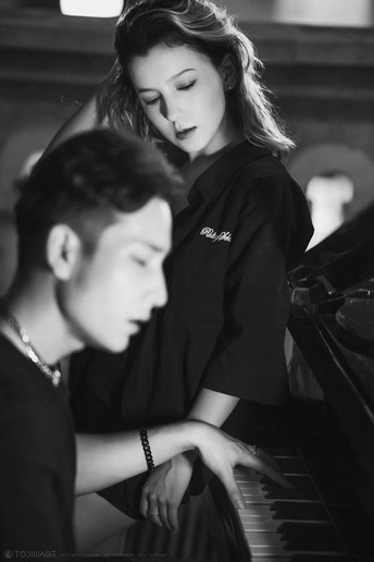 一张年轻男孩和女孩坐在钢琴前的黑白照片