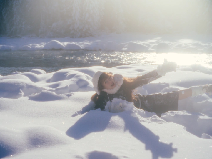 一个年轻女子躺在雪地里 太阳落山了