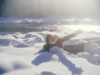 一个年轻女子躺在雪地里 太阳落山了