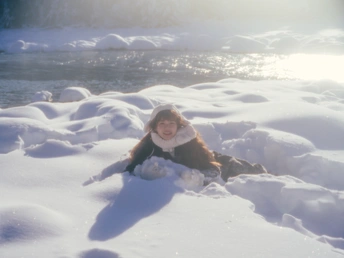 一个小女孩在河边玩雪
