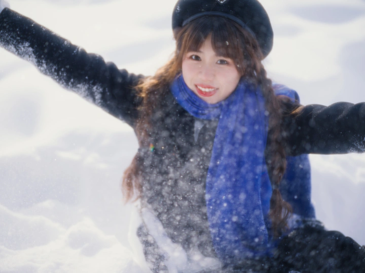 一位年轻女子在雪中张开双臂