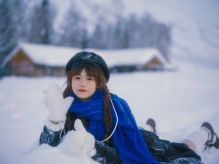 一个年轻女子坐在雪地里抱着一个小毛绒玩具