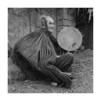 一张老照片 一个男子坐着弹奏乐器