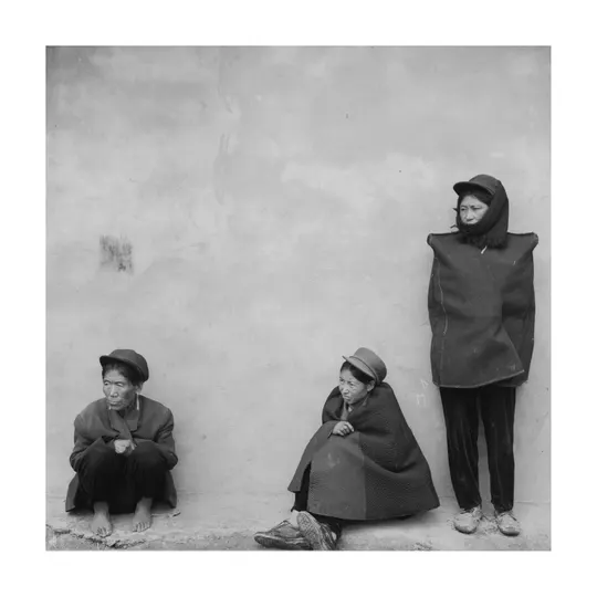 黑白照片 一个人、一个女人和一个孩子坐在墙上