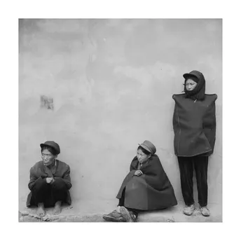 黑白照片 一个人、一个女人和一个孩子坐在墙上