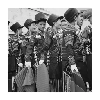 一群身着制服和戴帽子的女性站在一队士兵的前面。