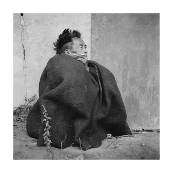 黑白照片 一位老人坐在街上 一个孩子裹着毛毯。