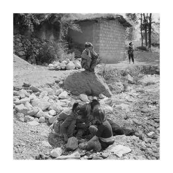 一群男性和儿童坐在一些岩石上