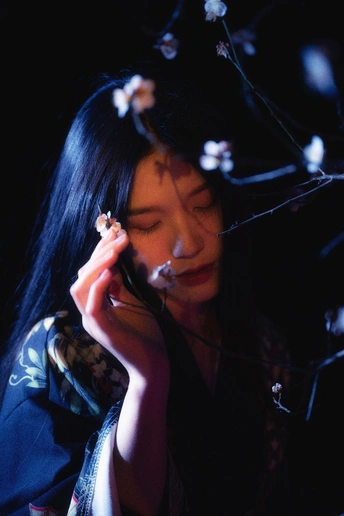 一位年轻女子正在耳边拿着手机 脸上盛开着鲜花。